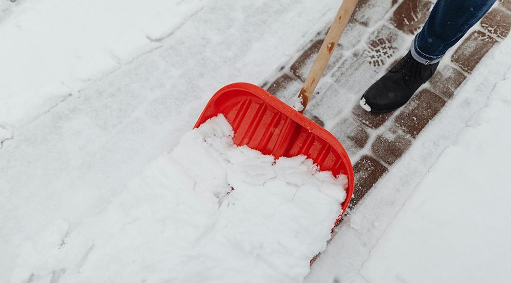 Snöskyffel som tar bort snön på en gångväg